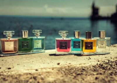 6 Parfumflaschen stehen auf einer Mauer vor dem See